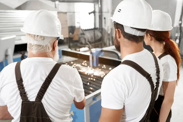 Ingenieros que observan el corte por láser de plasma de metal . — Foto de Stock