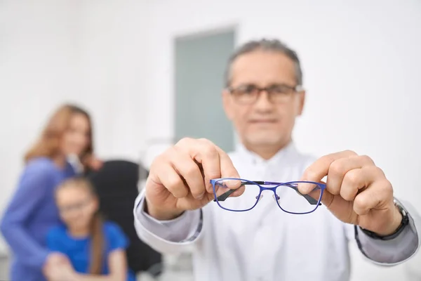 Primer plano de los anteojos azules médico sosteniendo en las manos . —  Fotos de Stock