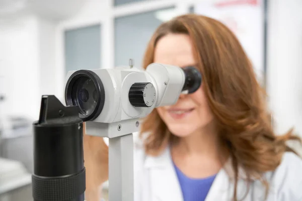 Primer plano del oftalmólogo mirando en lámpara de hendidura . —  Fotos de Stock