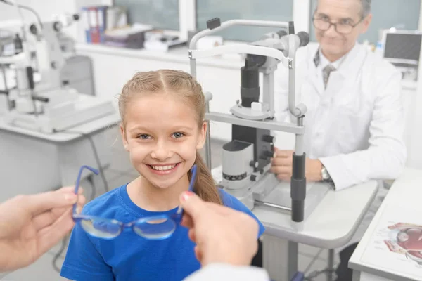 Ragazza in consultazione con l'optometrista, scegliendo gli occhiali . — Foto Stock