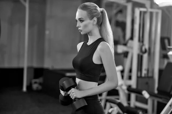 Atlético, chica activa haciendo ejercicio con mancuernas en el gimnasio . —  Fotos de Stock