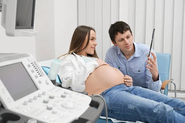 Futuros padres felices en el diagnóstico de utrasonido en clínica . — Foto de Stock