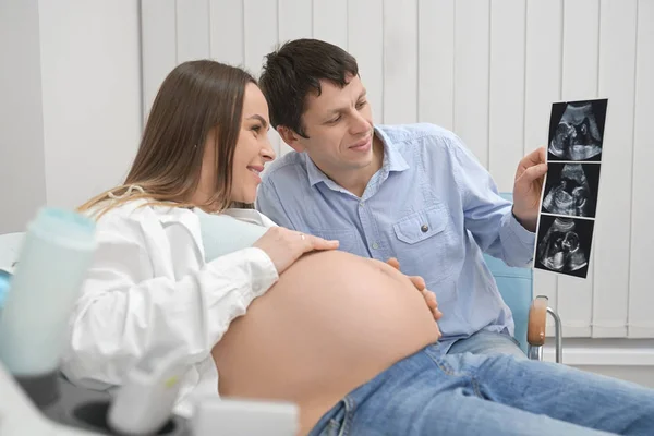 快乐的丈夫和妻子看着未来宝宝的 x 射线. — 图库照片