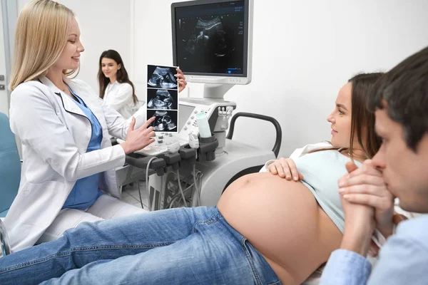Docteur montrant rayons X à la future mère et le père . — Photo