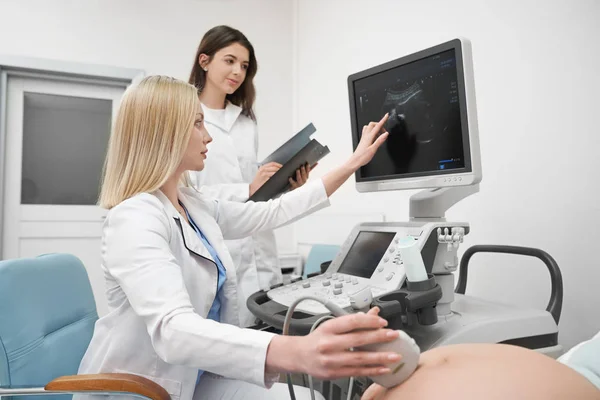 Врачи проводят ультразвуковую диагностику беременной женщины . — стоковое фото