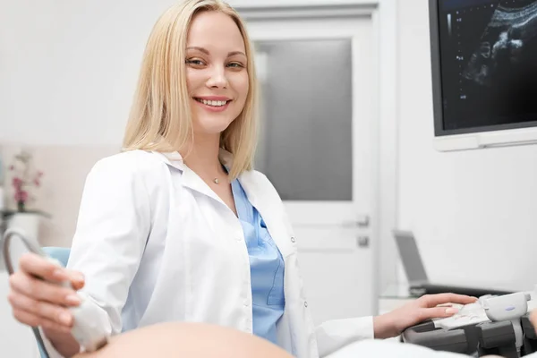 Mulher bonita, médico posando, sorrindo, segurando dispositivo . — Fotografia de Stock