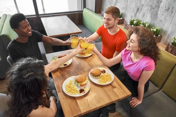 Grupp av vänner som sitter i café vid bordet, spottar glasögon. — Stockfoto