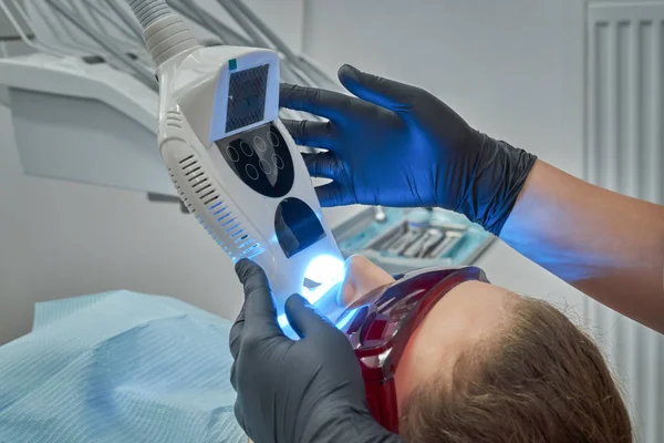 Mujer acostada en la silla durante el procedimiento de blanqueamiento de dientes —  Fotos de Stock