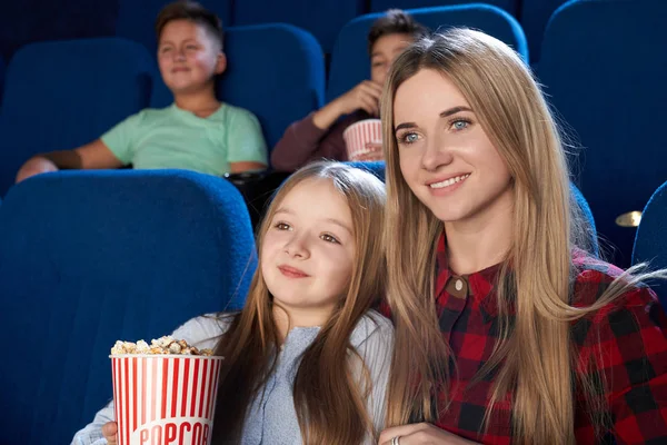 Szép anya és lánya nézi film mozi. — Stock Fotó