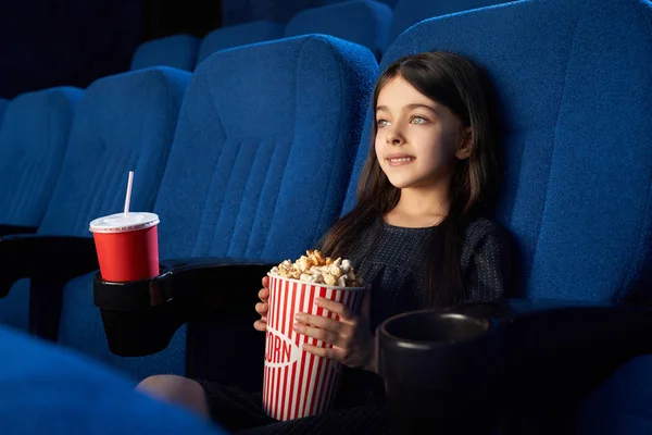 Χαριτωμένο παιδί κάθεται με ποπ κορν κουβά στον κινηματογράφο. — Φωτογραφία Αρχείου