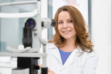 Beyaz önlük ile poz içinde doktor optometrist lamba kesti.