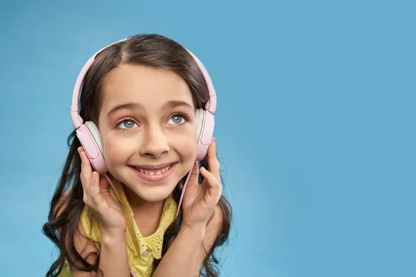 Criança feliz em fones de ouvido ouvindo música favorita em estúdio — Fotografia de Stock