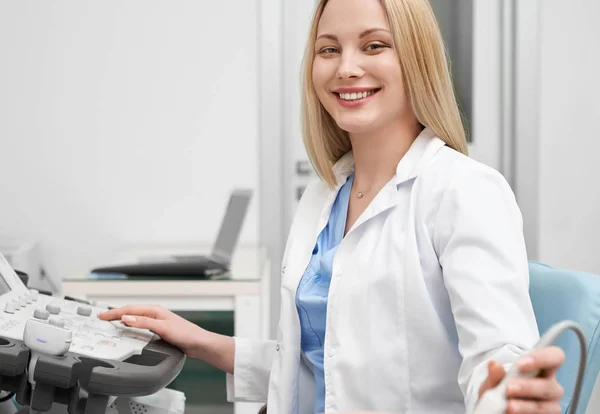 Beyaz üniforma kameraya bakarak pozitif kadın doktor — Stok fotoğraf