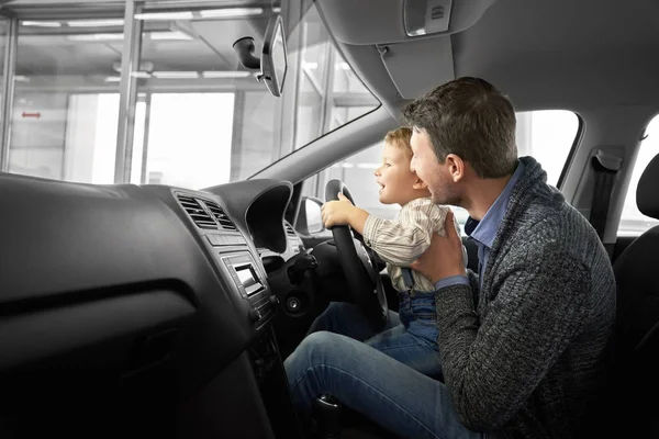 Любимая семья тестирует комфортабельную машину в автосалоне — стоковое фото