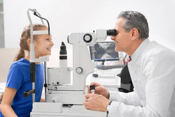 Pen jente som tar øyeprøver på legekontoret. . – stockfoto