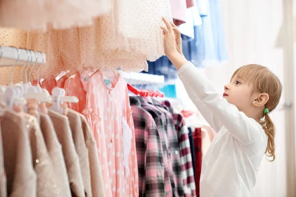 Aranyos lány, modern, stílusos gyermek ruházat kiválasztása. — Stock Fotó