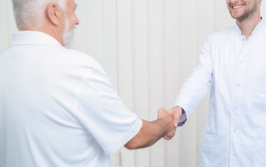 Parlak ofiste el sallayarak iki doktorun yakın.