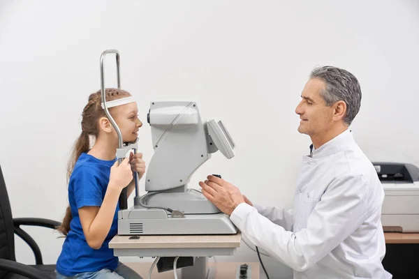 医务人员在临床上检查小女孩的视力 — 图库照片