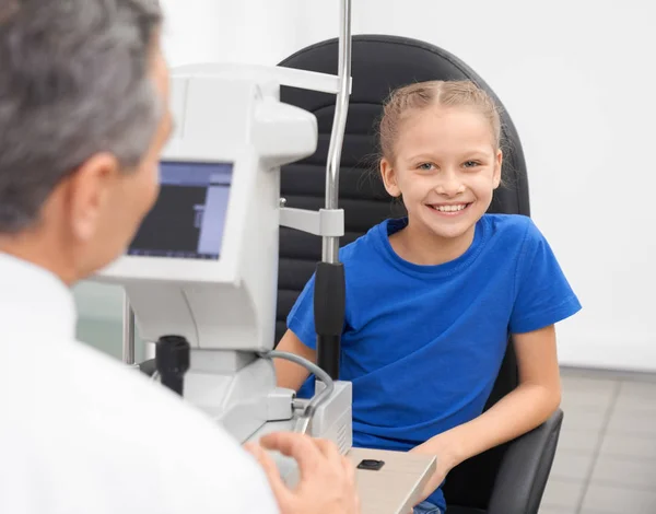 Ragazza felice seduta in clinica e controllare la vista — Foto Stock