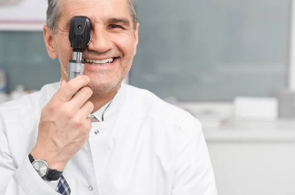 Oculista guardando la fotocamera attraverso strumento oftalmologico — Foto Stock
