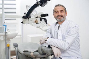 Modern klinikte işyerinde poz veren diş hekimi.