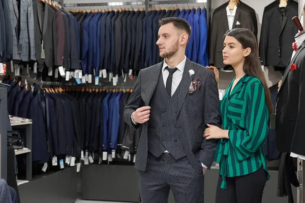 Cliente na loja escolhendo roupas, assistente de loja ajudando . — Fotografia de Stock