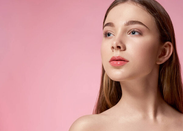 Lady with natural make up posing on pink background.