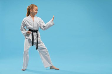 Beyaz kimono eğitim karate gülümseyen kız Yan görünümü