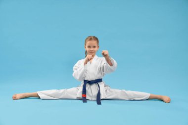 Küçük spor kadın stüdyoda çapraz ip üzerinde oturan