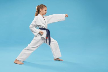 Kimono duruşunda duran konsantre kızın yan görünümü