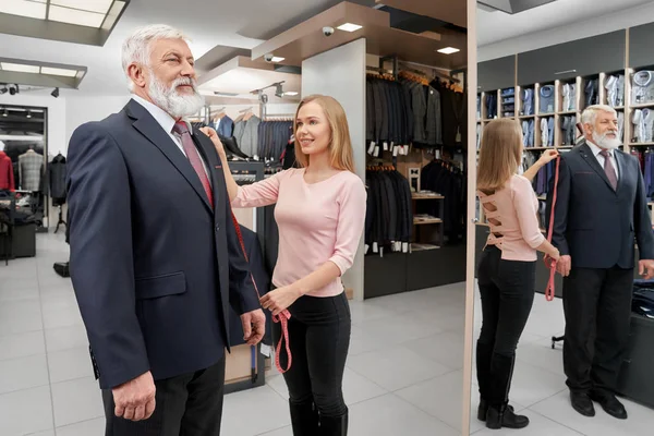 Homem mais velho elegante experimentando um novo terno formal na boutique — Fotografia de Stock