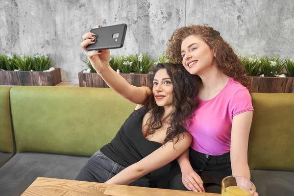 Side view of two best friends doing selfie in cafe — Stock Photo, Image