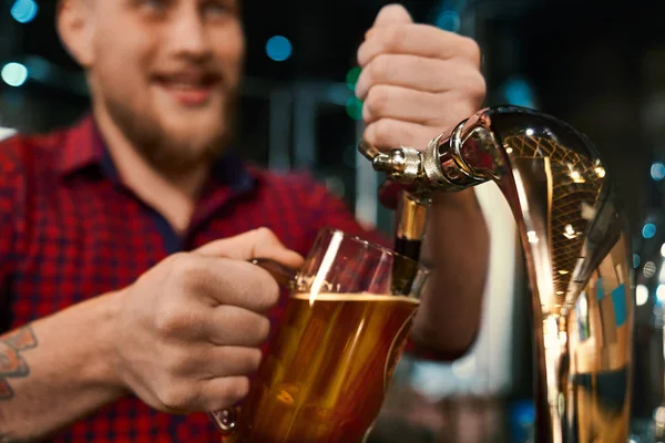 Maschio barman poring birra in pinta in pub — Foto Stock