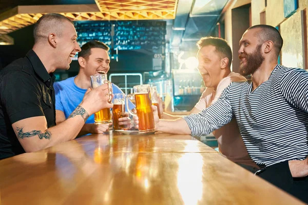 술집에서 저녁을 즐기는 행복한 남성 회사의 사이드 뷰 — 스톡 사진