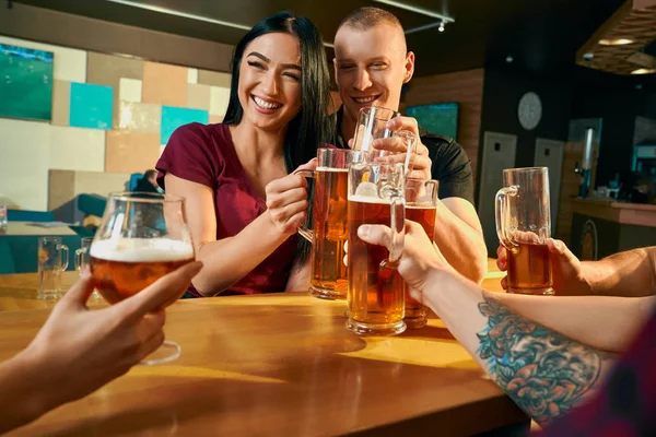 Framsidan av glada par skrattar medan du dricker öl — Stockfoto