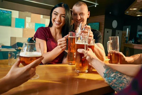 맥주를 마시면서 웃고 있는 쾌활한 쌍의 정면 — 스톡 사진