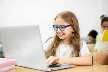 Dizüstü bilgisayarda çalışan sınıfta masada Schoolgirl.
