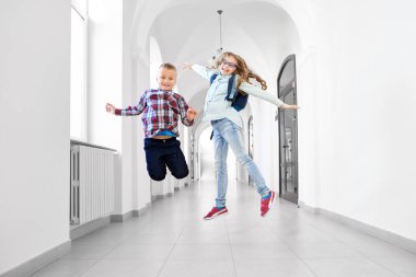 Mutlu öğrenciler poz, okulda atlama.