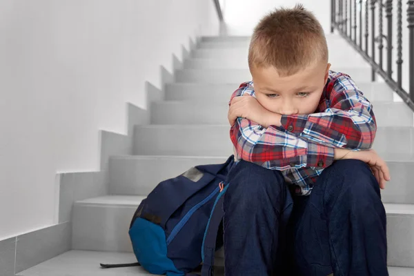 계단에 앉아 초등학교의 슬픈 소년. — 스톡 사진