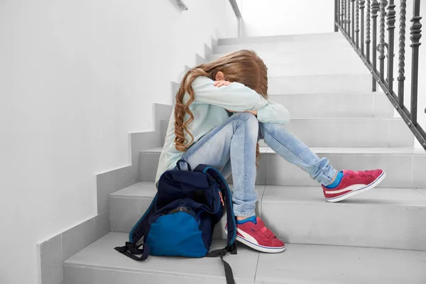 Estudante triste sentado nas escadas, escondendo o rosto . — Fotografia de Stock