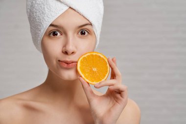 Model tutan el Turuncu dilim, kamera bakıyor