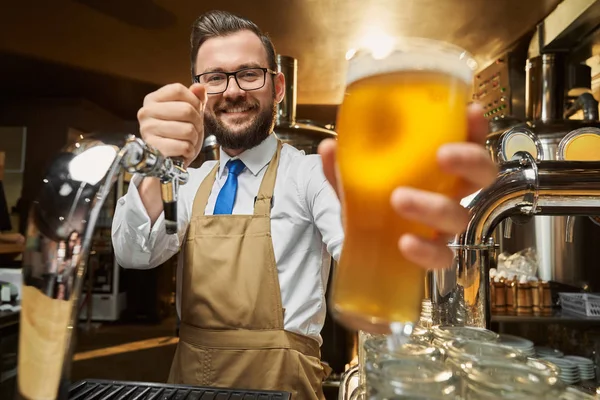 Lager piwo szklane z pianki w barmanów rękę z bliska. — Zdjęcie stockowe