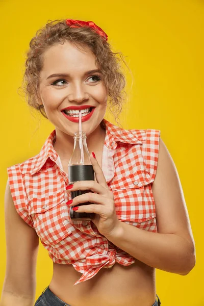 Sexy girl with perfect red lips holding fizzy drink bottle.