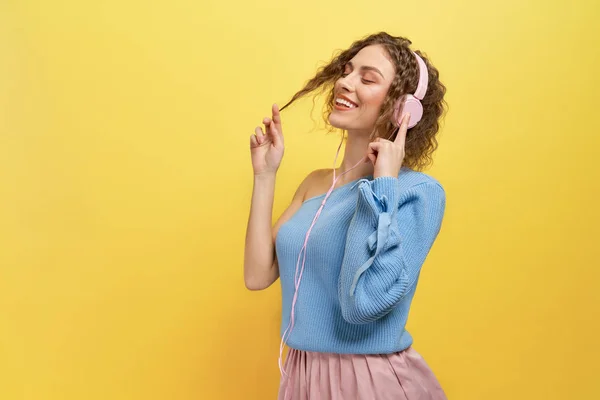 Modelo escuchar música con auriculares con los ojos cerrados . — Foto de Stock