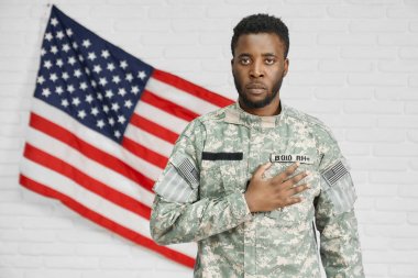 Amerikan askeri kameraya bakarak kalp el tutarak.