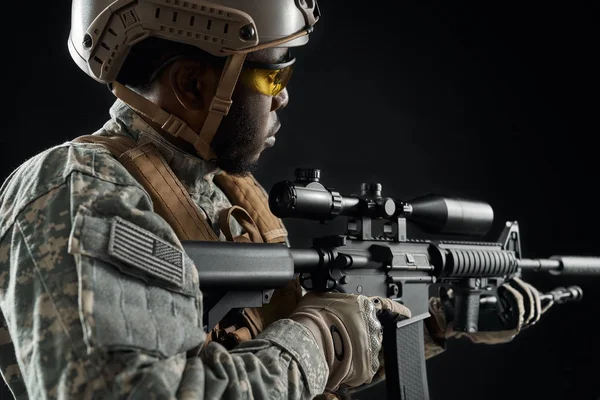 Soldado americano sosteniendo el arma en las manos y manteniendo la vista . —  Fotos de Stock