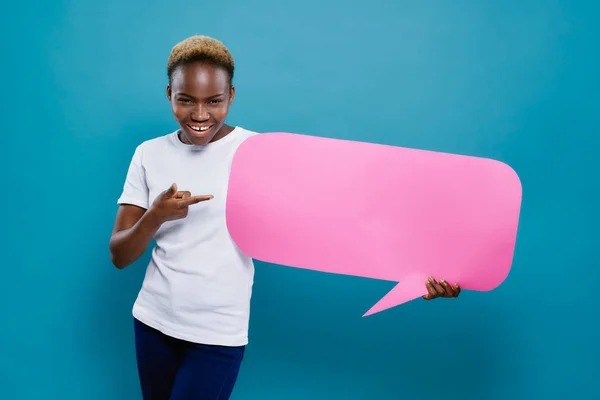 African girl holding speech bubble and pointing with finger.