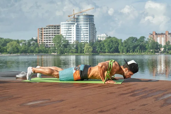 Brazo de hombre deportivo desde muelle de madera con rayas de silicona . — Foto de Stock