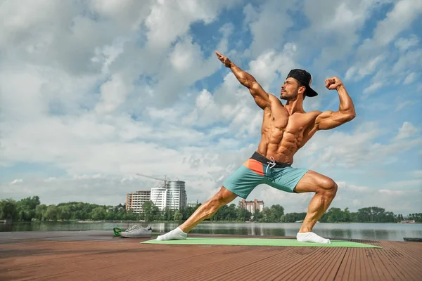 Hombre más fuerte posando con las manos arriba, mostrando sus músculos . — Foto de Stock