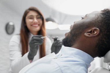 Açık ağızlı diş sandalyesinde yatan adamın seçici odak noktası